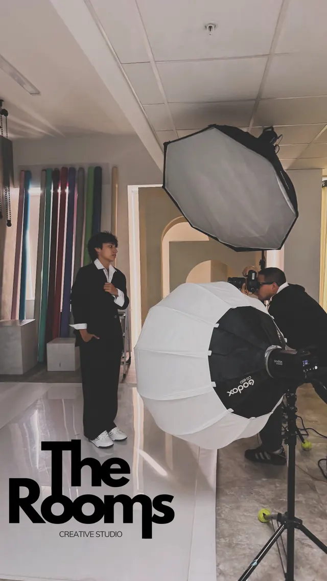 Sesión con traje negro entre softboxes y rollers de color