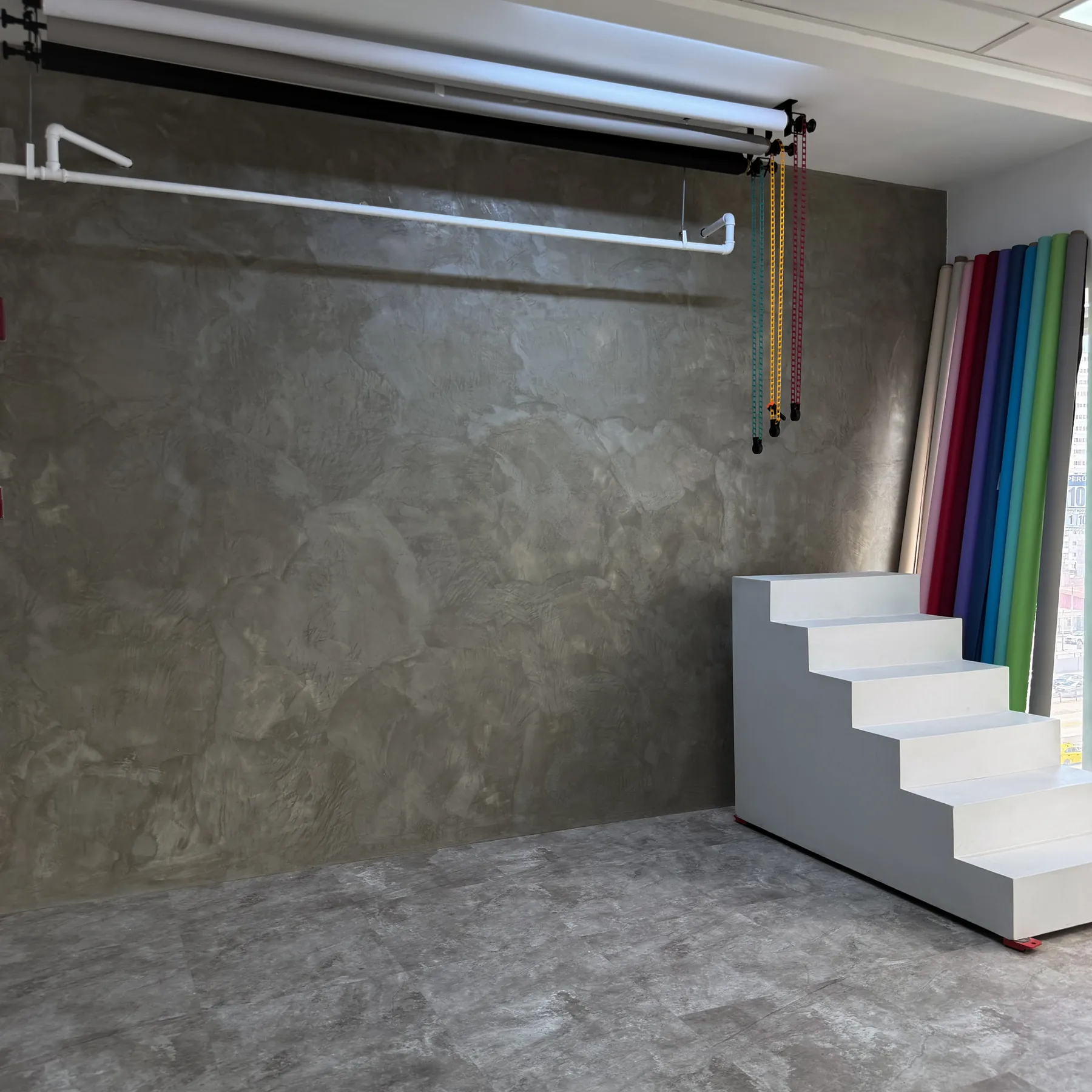 Wall Room con pared de microcemento, rollers de color y escalera editorial